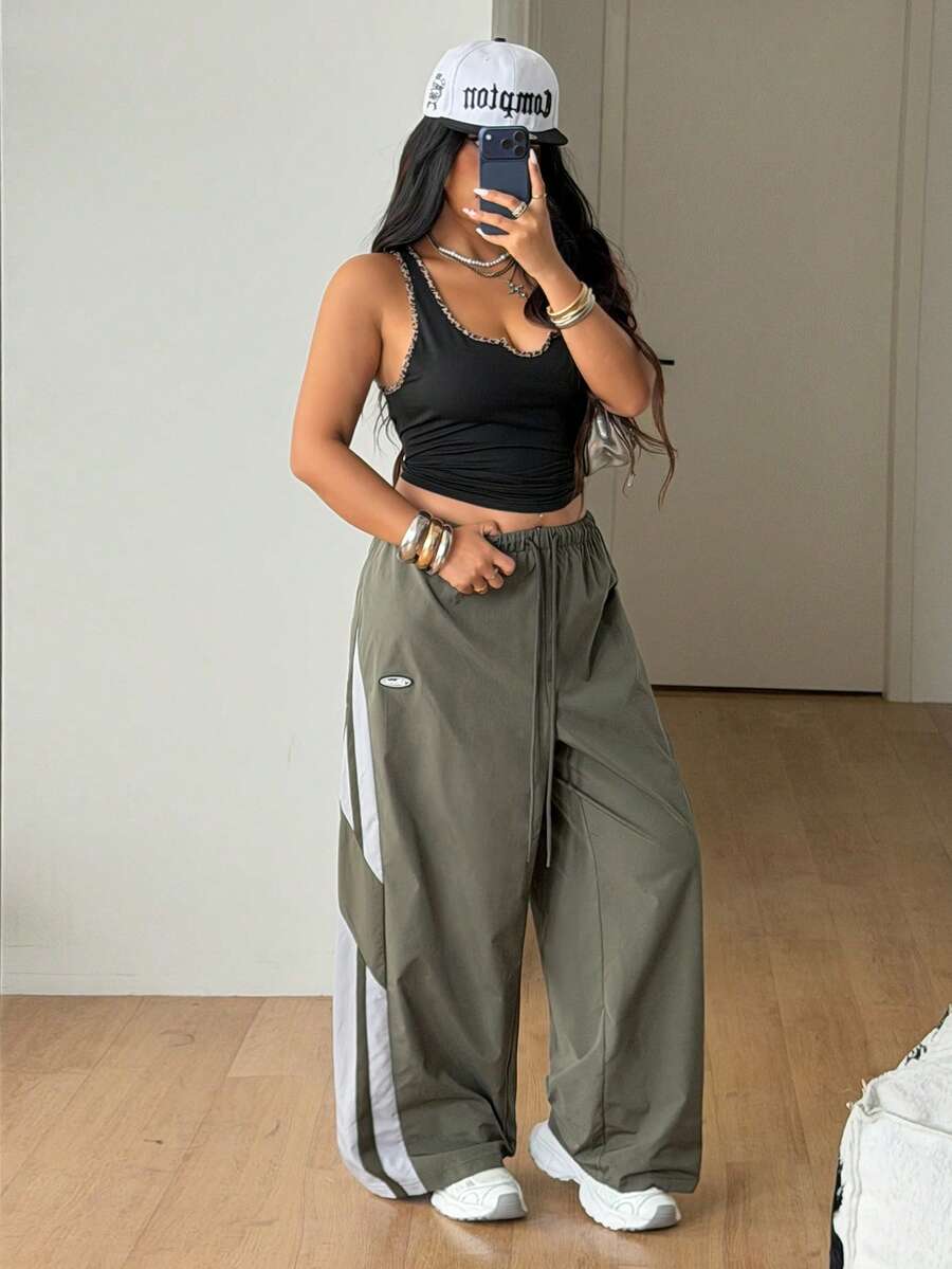 Women's plus size loose straight leg pants featuring a black and white color block design with side stripes and an elastic drawstring waist.
