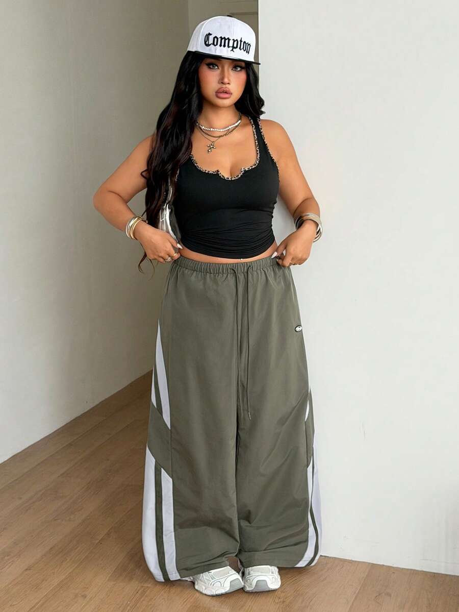 Women's plus size loose straight leg pants featuring a black and white color block design with side stripes and an elastic drawstring waist.