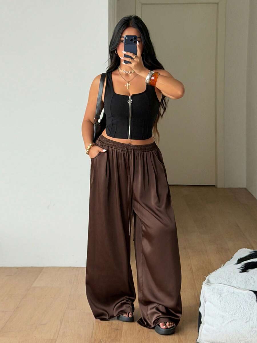 Women's loose straight leg cotton pants featuring a high waist with an adjustable drawstring knot and functional side pockets.