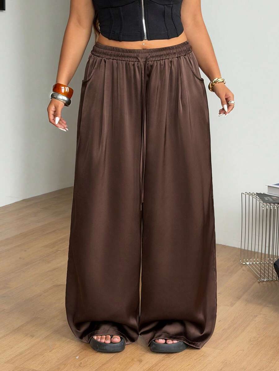 Women's loose straight leg cotton pants featuring a high waist with an adjustable drawstring knot and functional side pockets.