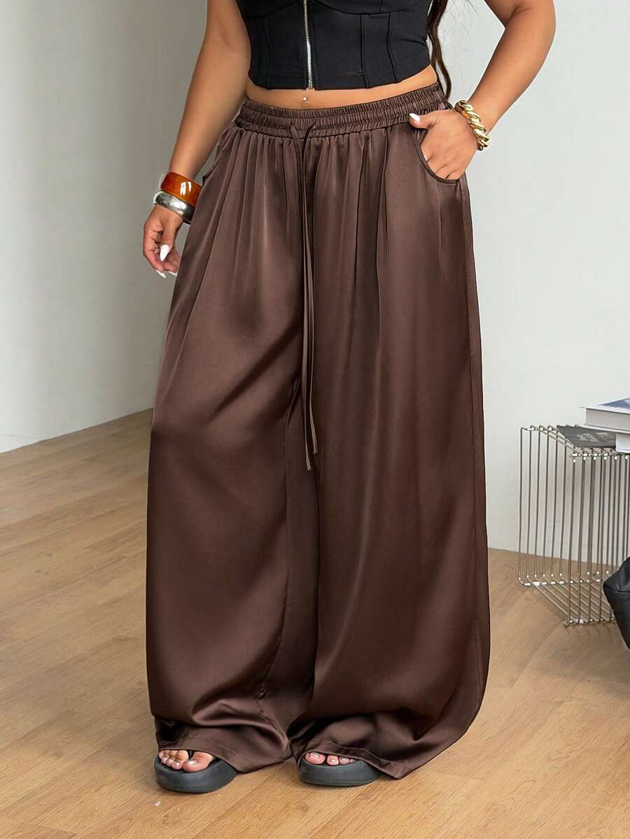 Women's loose straight leg cotton pants featuring a high waist with an adjustable drawstring knot and functional side pockets.