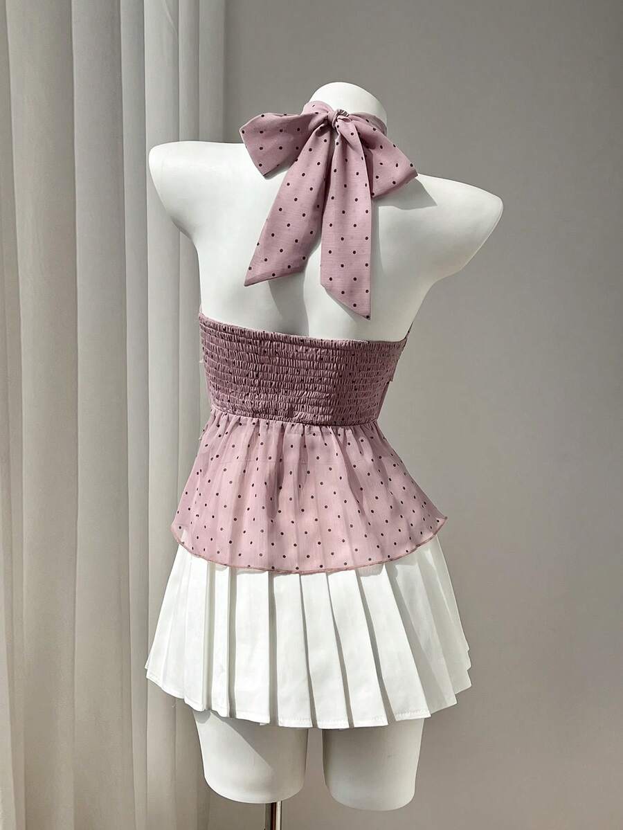 Women's white sleeveless halter neck top featuring pleated fabric, backless tie strap design, and a flared layered ruffle hem.