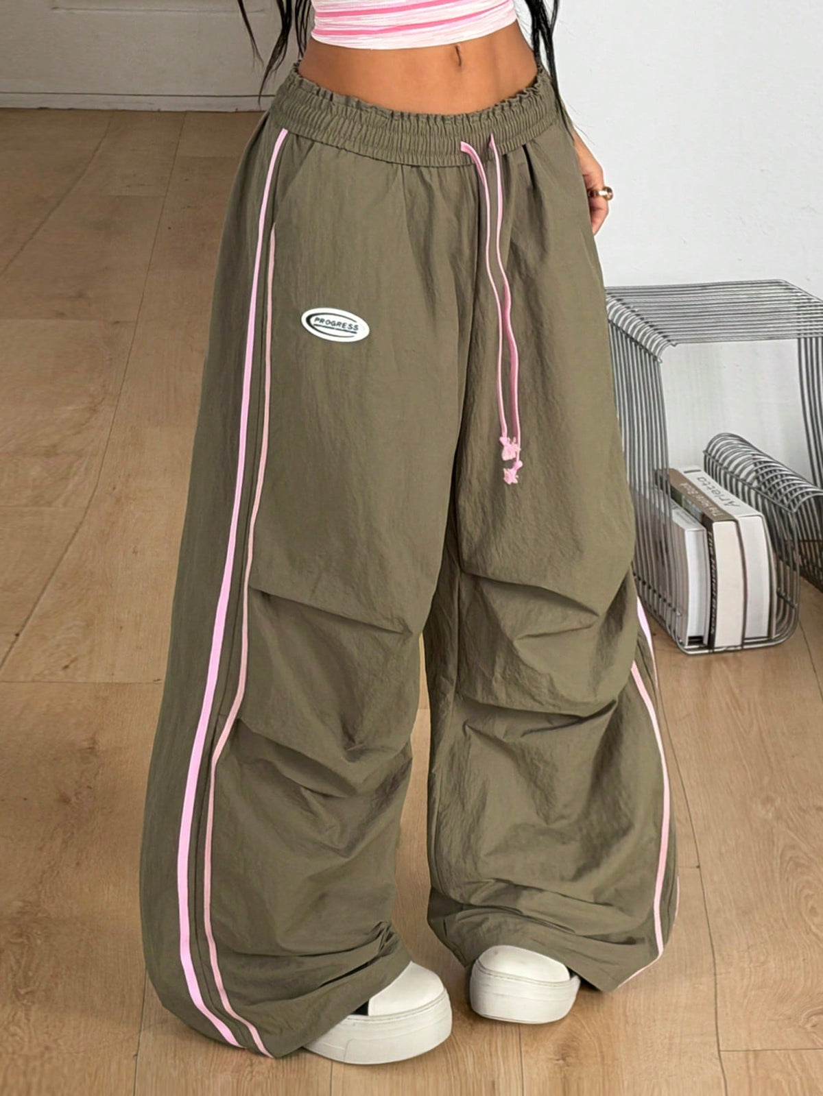 Women's black and white striped wide leg pants featuring an elastic drawstring waistband, side pockets, and a loose straight leg fit.