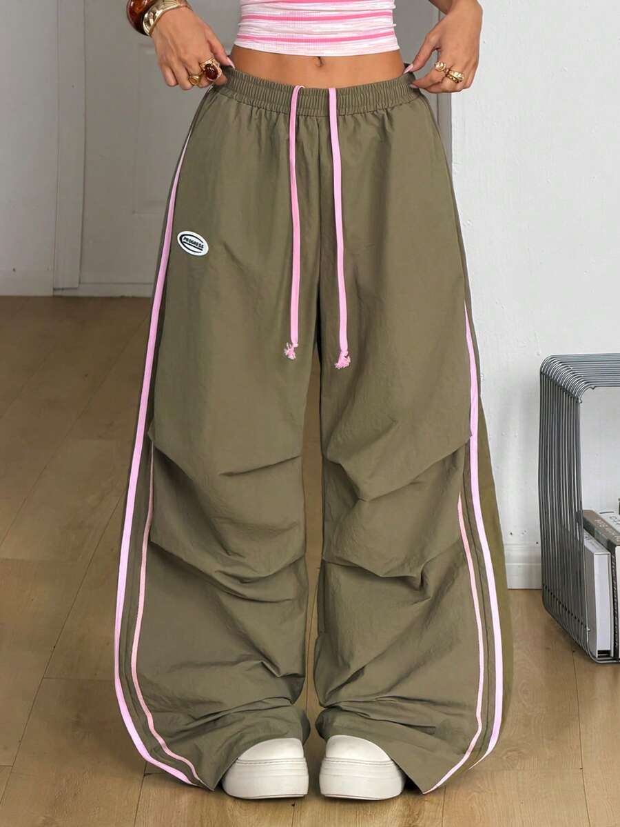 Women's black and white striped wide leg pants featuring an elastic drawstring waistband, side pockets, and a loose straight leg fit.
