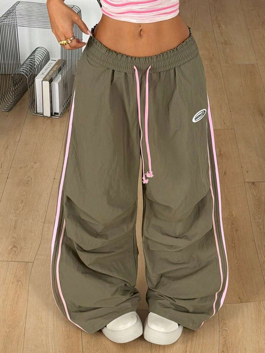 Women's black and white striped wide leg pants featuring an elastic drawstring waistband, side pockets, and a loose straight leg fit.