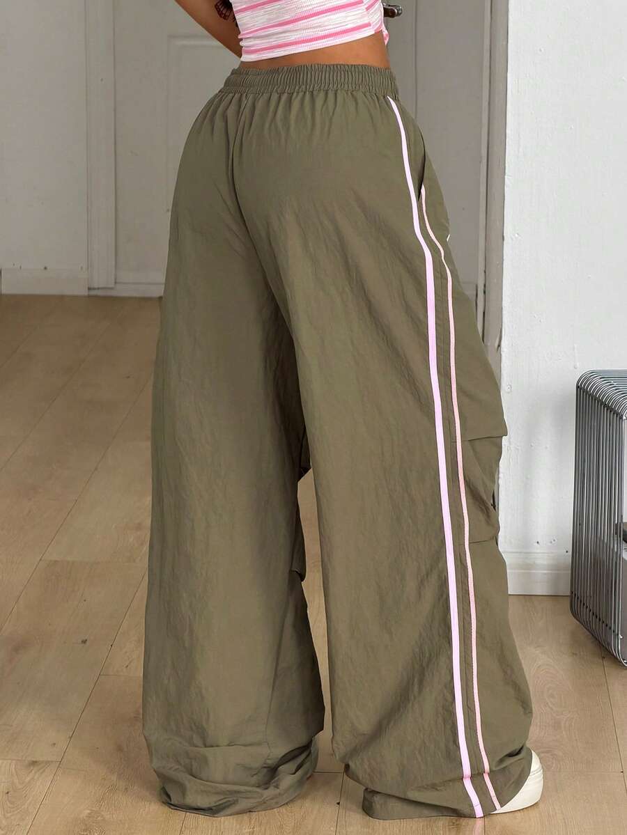 Women's black and white striped wide leg pants featuring an elastic drawstring waistband, side pockets, and a loose straight leg fit.