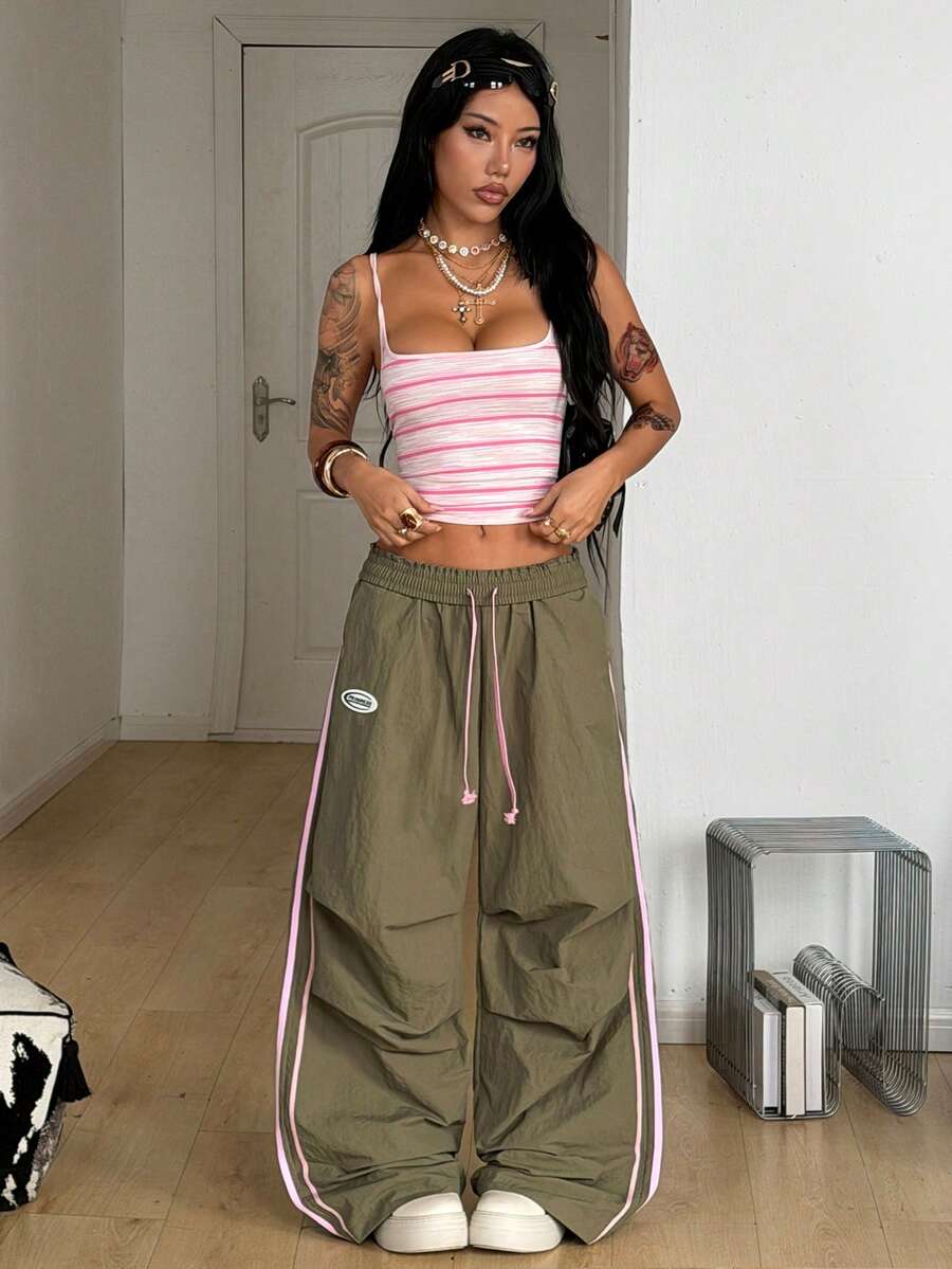 Women's black and white striped wide leg pants featuring an elastic drawstring waistband, side pockets, and a loose straight leg fit.