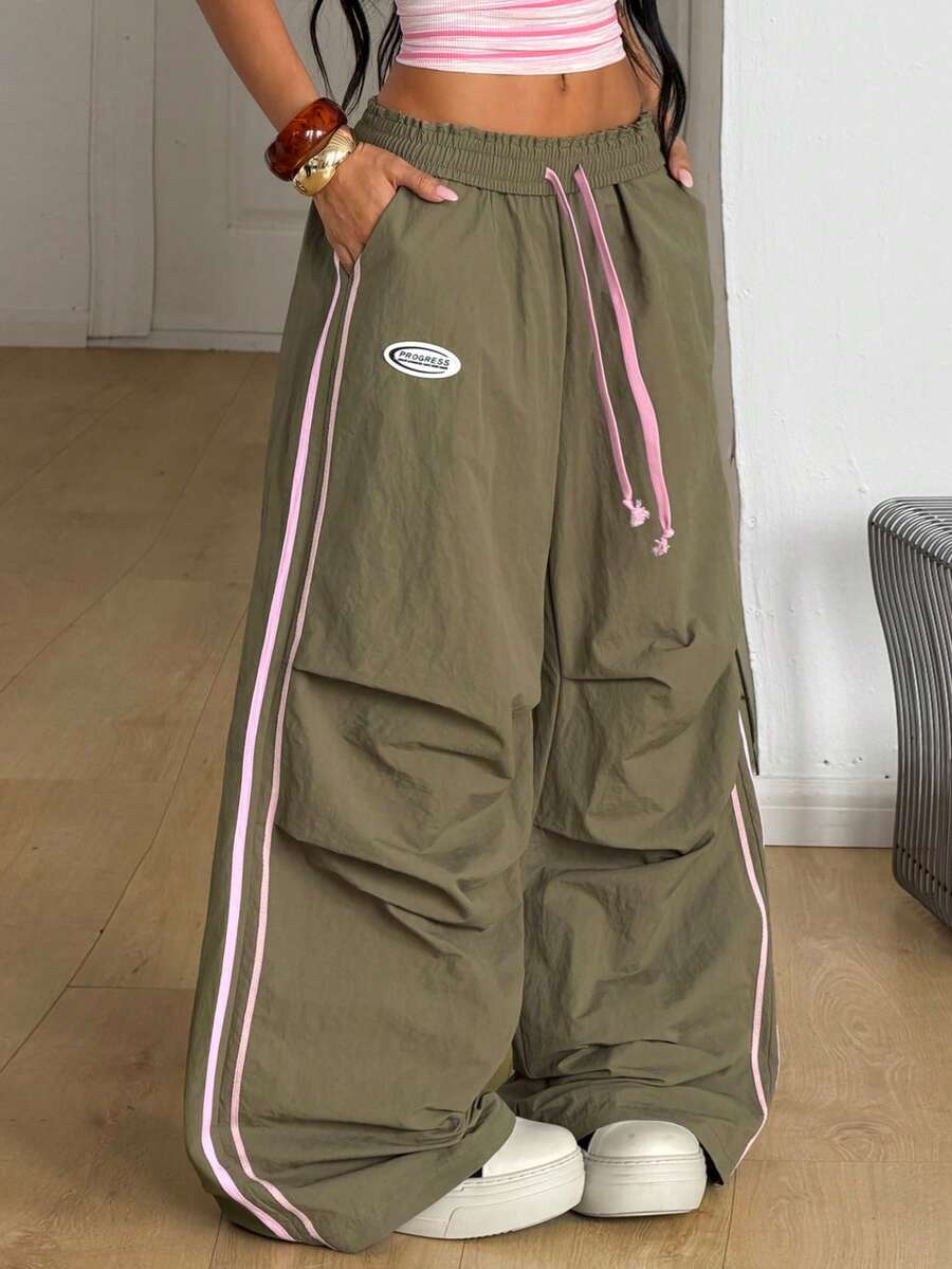 Women's black and white striped wide leg pants featuring an elastic drawstring waistband, side pockets, and a loose straight leg fit.