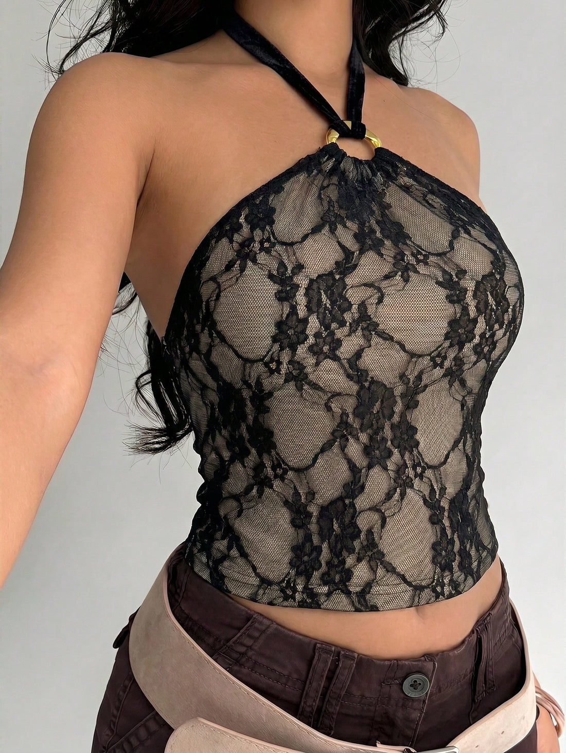 Women's black backless halter mesh crop top featuring knot and ring details with matching arm sleeves.