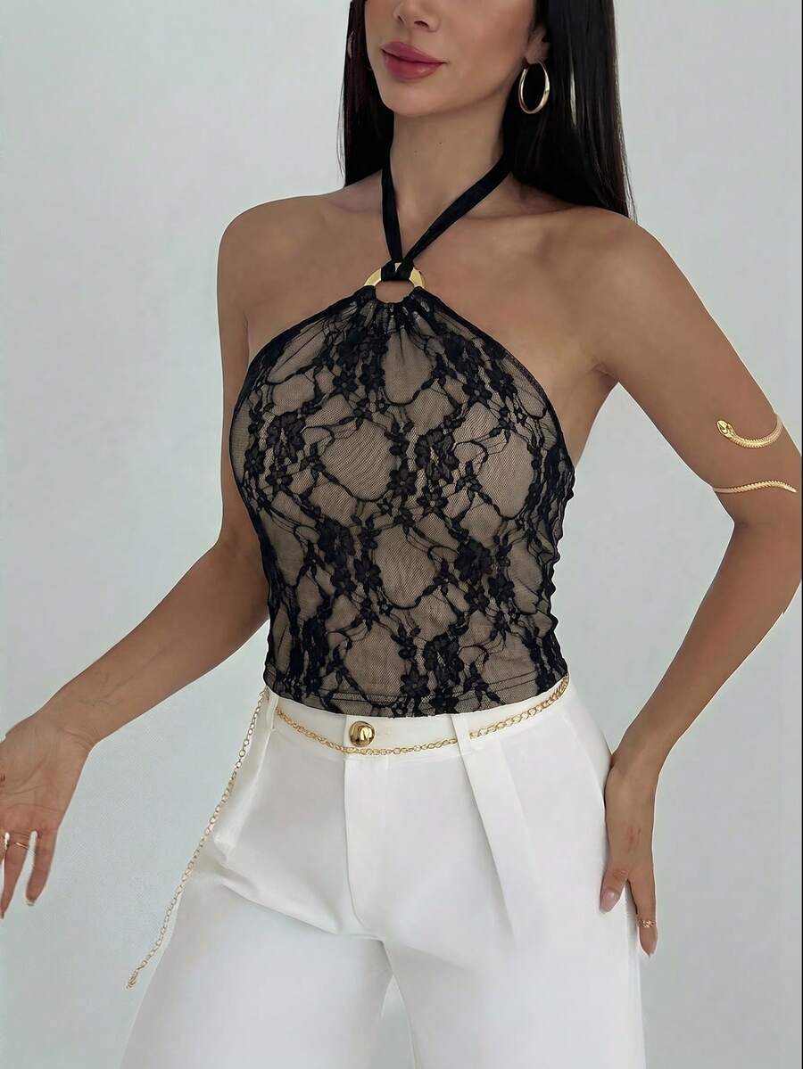 Women's black backless halter mesh crop top featuring knot and ring details with matching arm sleeves.