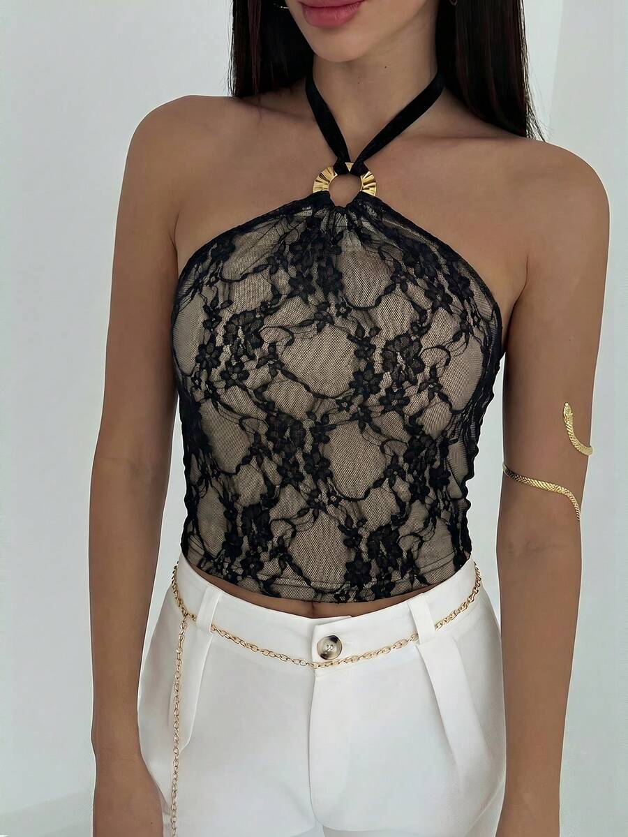 Women's black backless halter mesh crop top featuring knot and ring details with matching arm sleeves.
