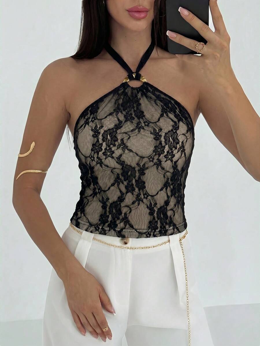 Women's black backless halter mesh crop top featuring knot and ring details with matching arm sleeves.