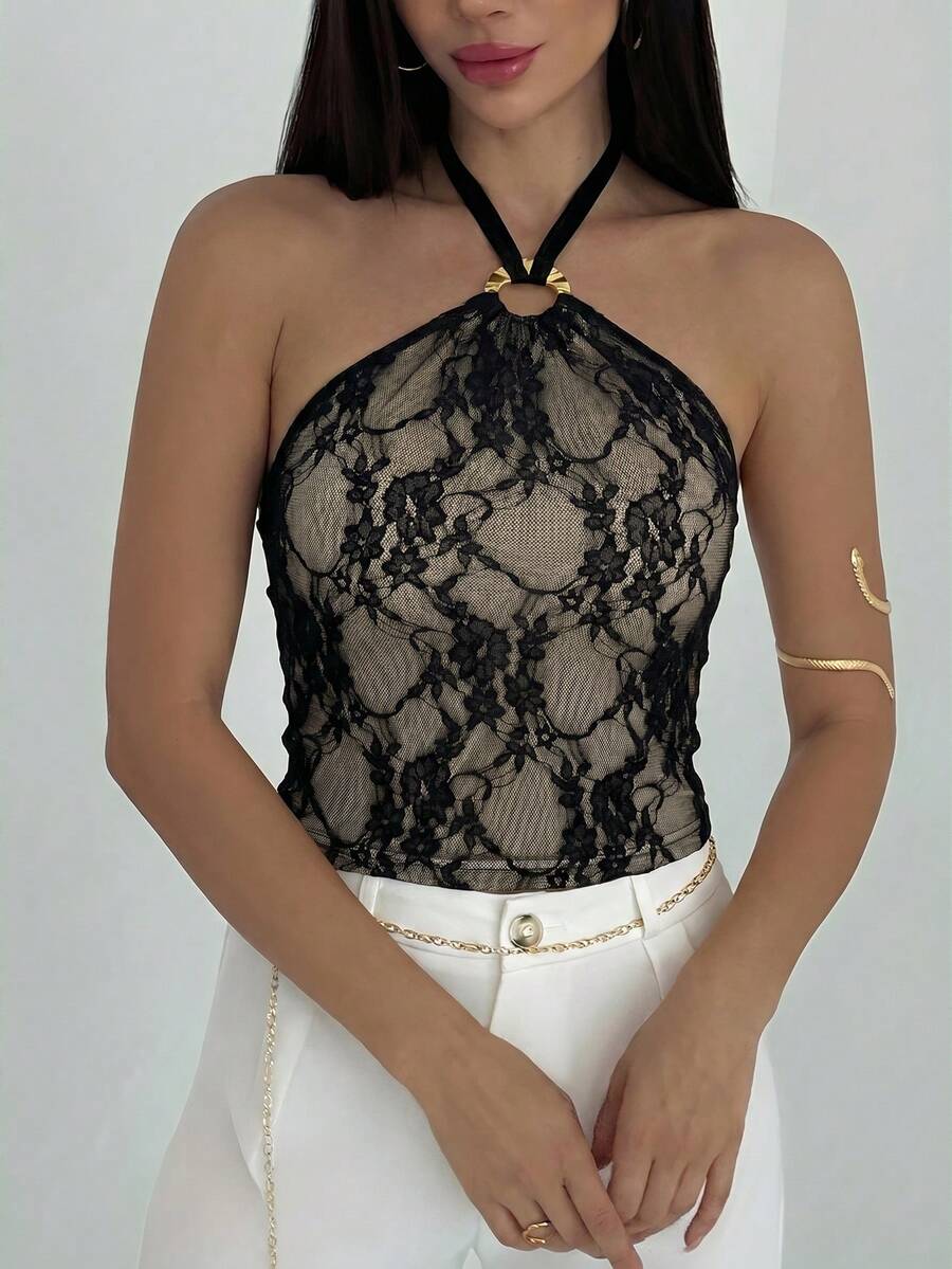 Women's black backless halter mesh crop top featuring knot and ring details with matching arm sleeves.