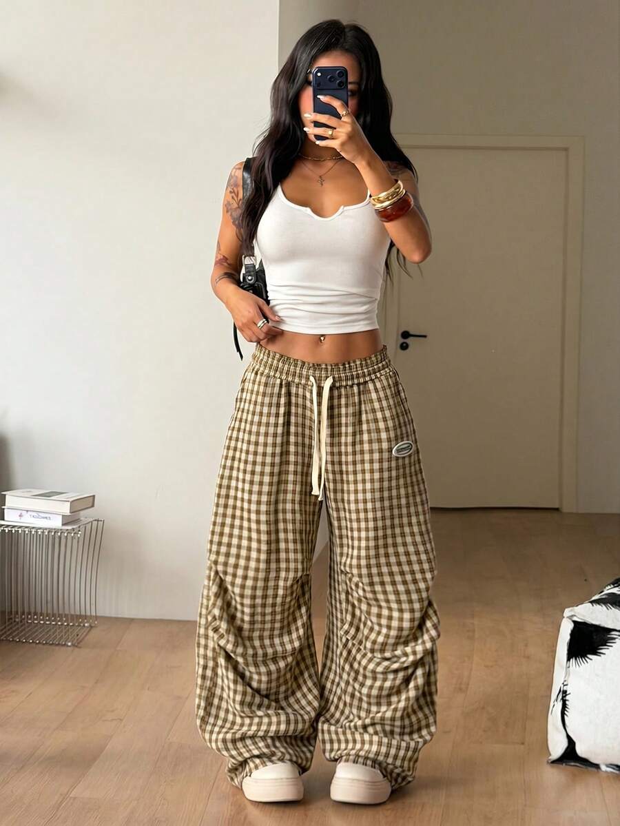 Women's black and white striped wide leg pants featuring an elastic drawstring waistband, side pockets, and a loose straight leg fit.