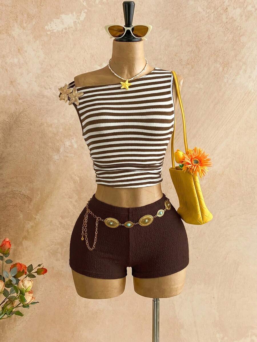 Women's black fuzzy knit two-piece set with an asymmetrical crop camisole top featuring ruched detail and cutout back, paired with matching mini shorts.