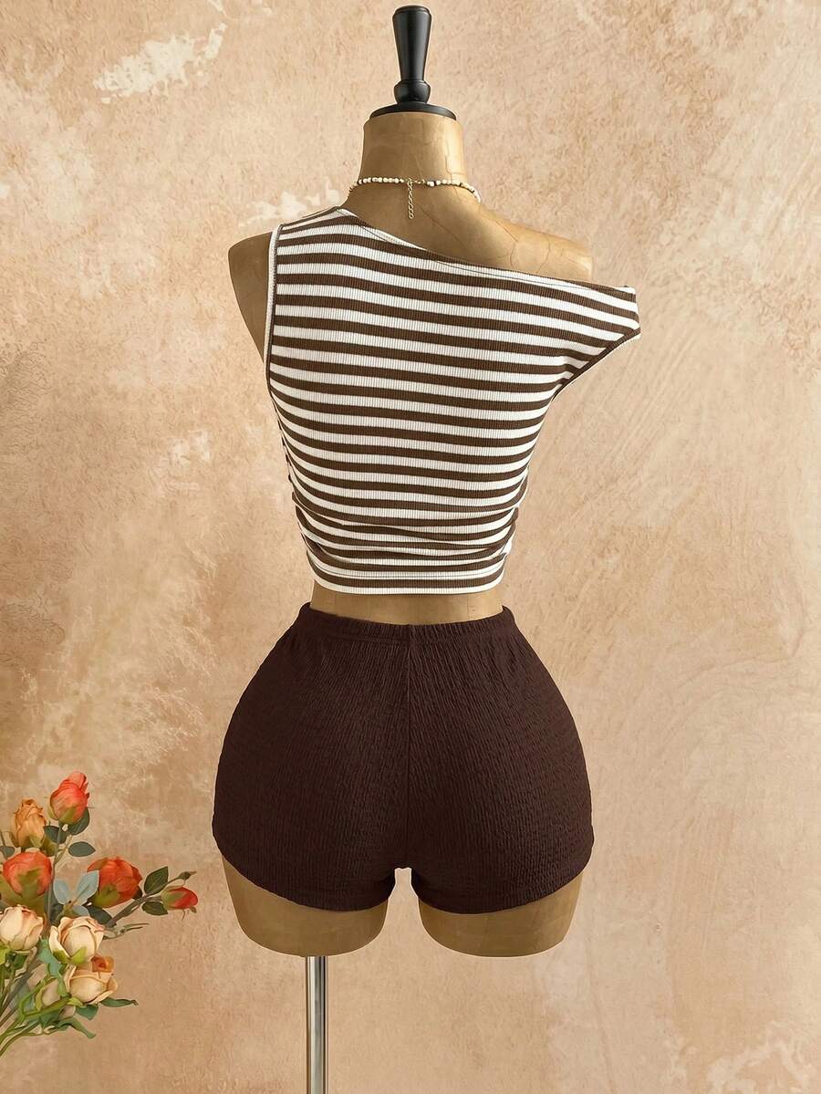 Women's black fuzzy knit two-piece set with an asymmetrical crop camisole top featuring ruched detail and cutout back, paired with matching mini shorts.