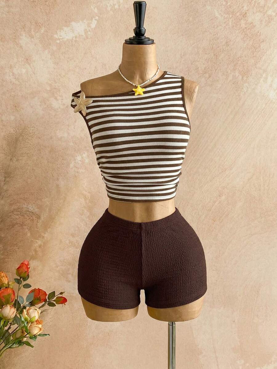 Women's black fuzzy knit two-piece set with an asymmetrical crop camisole top featuring ruched detail and cutout back, paired with matching mini shorts.