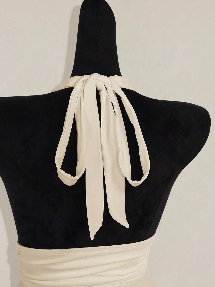 Women's backless halter babydoll tank top featuring a square neckline, slim fit silhouette, and a flared ruffle hem.