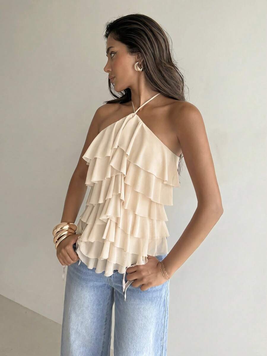 Women's sleeveless halter neck top featuring tiered ruffle layers, a backless cut, and an asymmetrical hem.