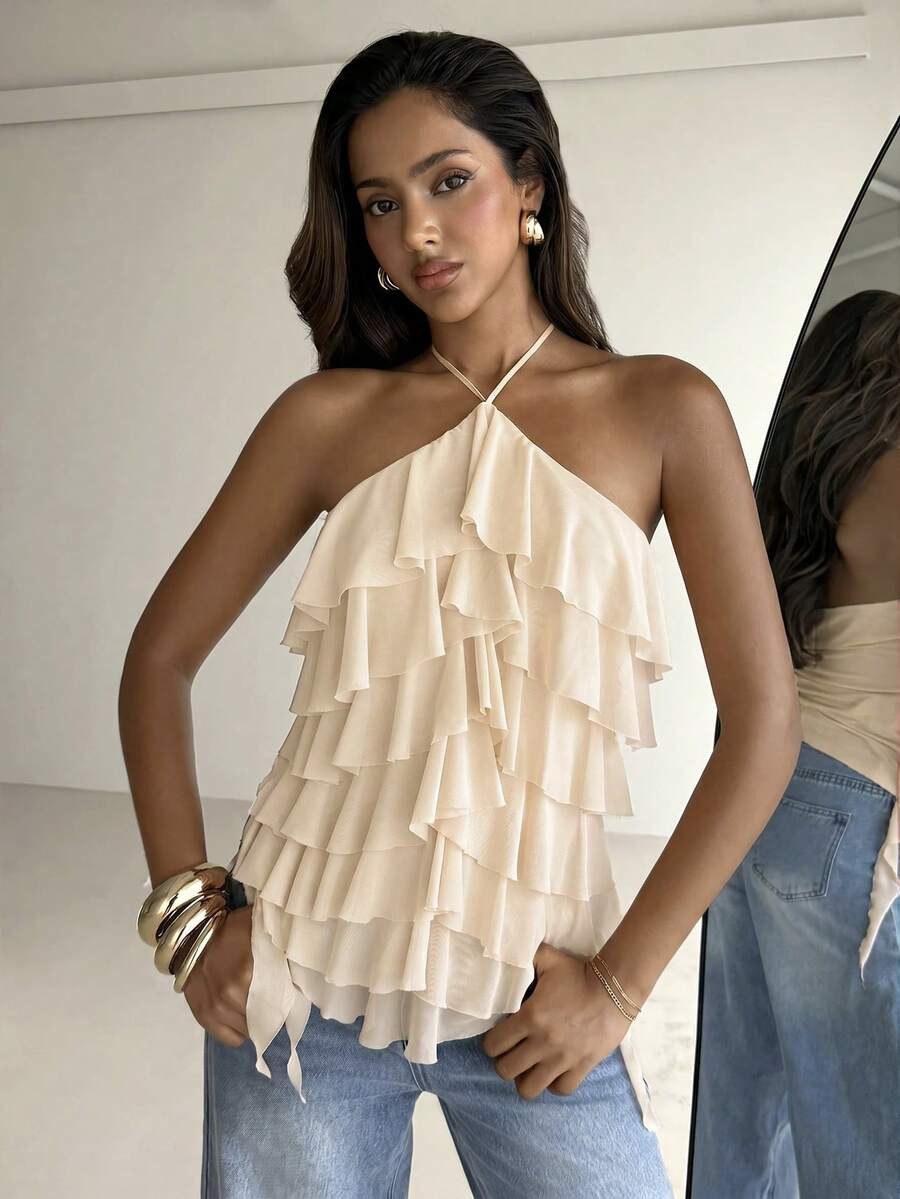 Women's sleeveless halter neck top featuring tiered ruffle layers, a backless cut, and an asymmetrical hem.