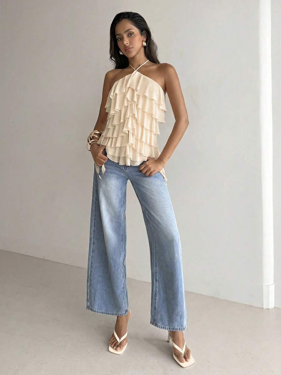 Women's sleeveless halter neck top featuring tiered ruffle layers, a backless cut, and an asymmetrical hem.