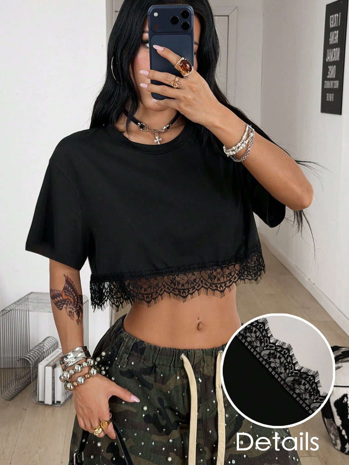 Women's short sleeve crop top with a round neckline and drop shoulder design in black knitted fabric.