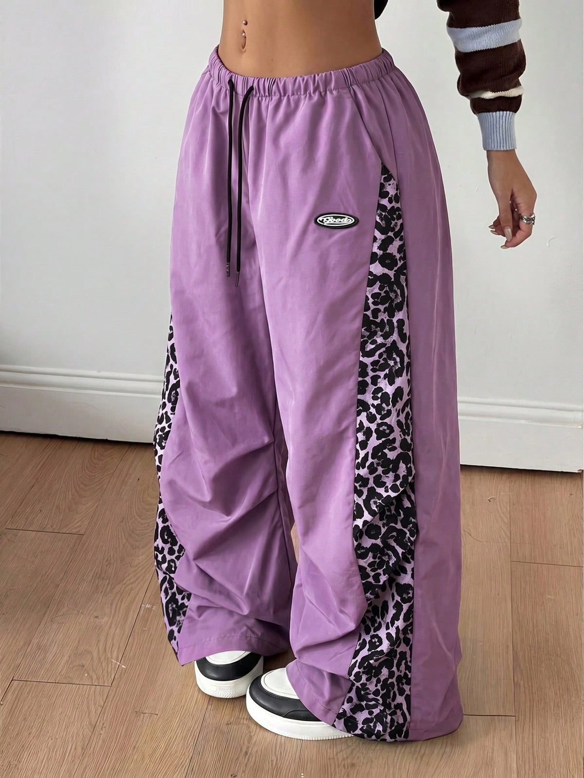 Women's black baggy jogger pants with an adjustable drawstring waist and colorblock polka dot geometric pattern.