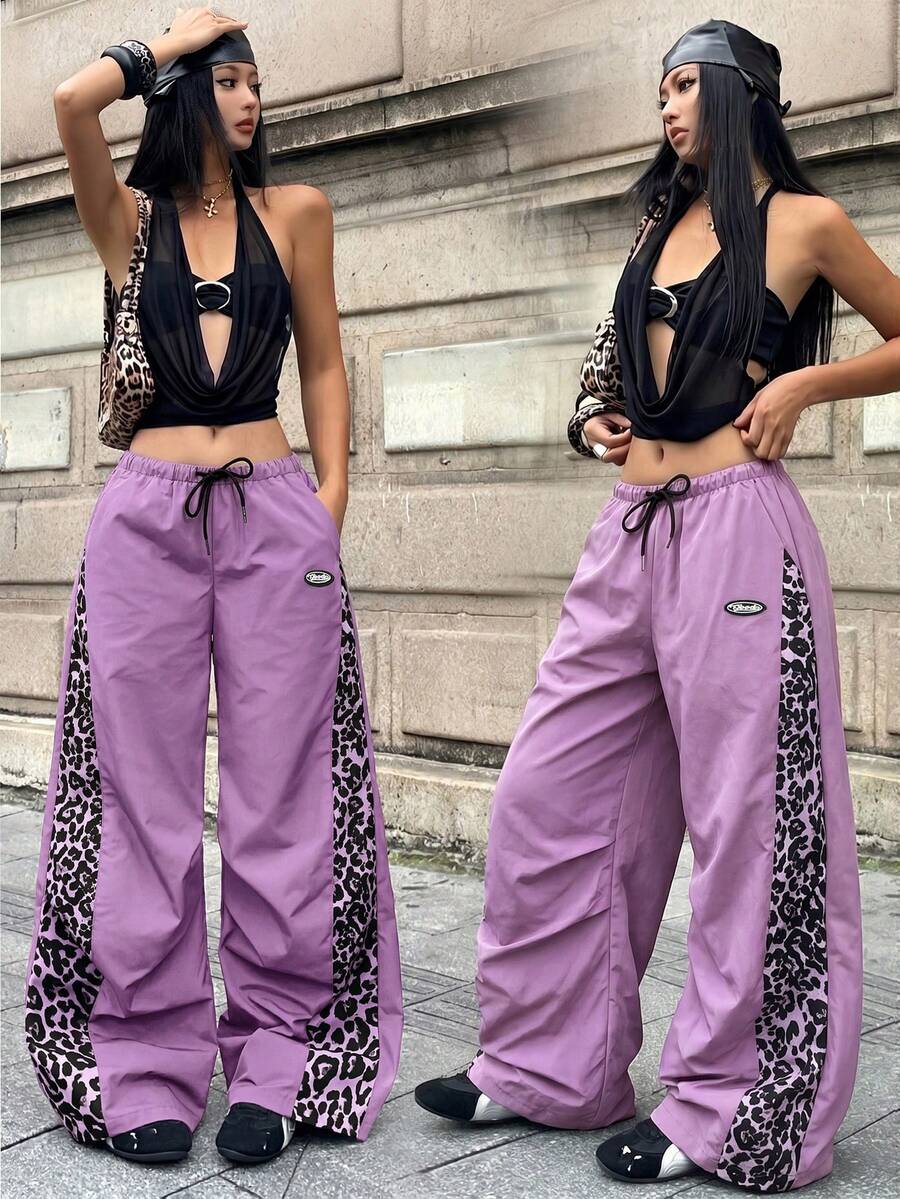 Women's black baggy jogger pants with an adjustable drawstring waist and colorblock polka dot geometric pattern.