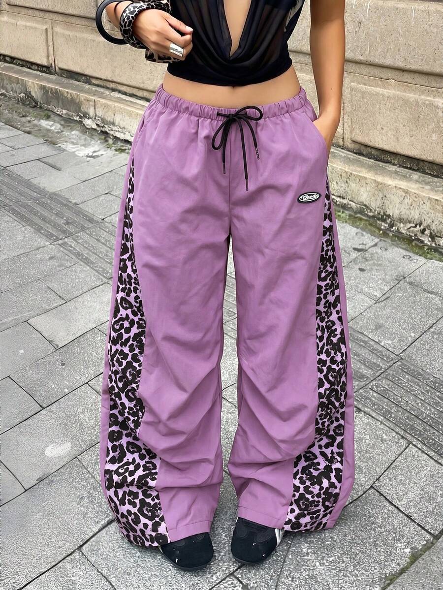Women's black baggy jogger pants with an adjustable drawstring waist and colorblock polka dot geometric pattern.