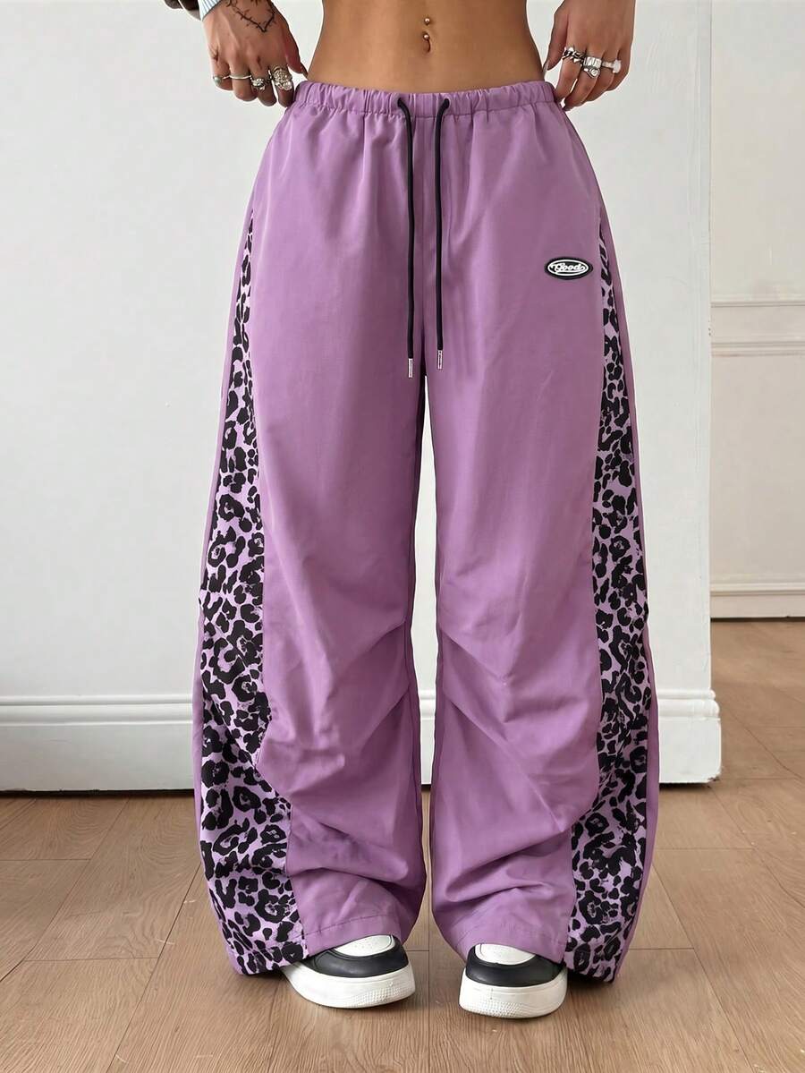 Women's black baggy jogger pants with an adjustable drawstring waist and colorblock polka dot geometric pattern.