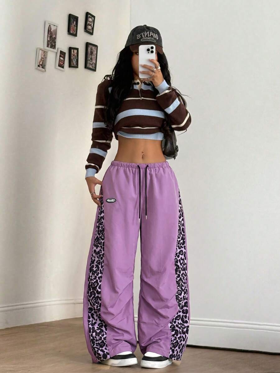 Women's black baggy jogger pants with an adjustable drawstring waist and colorblock polka dot geometric pattern.