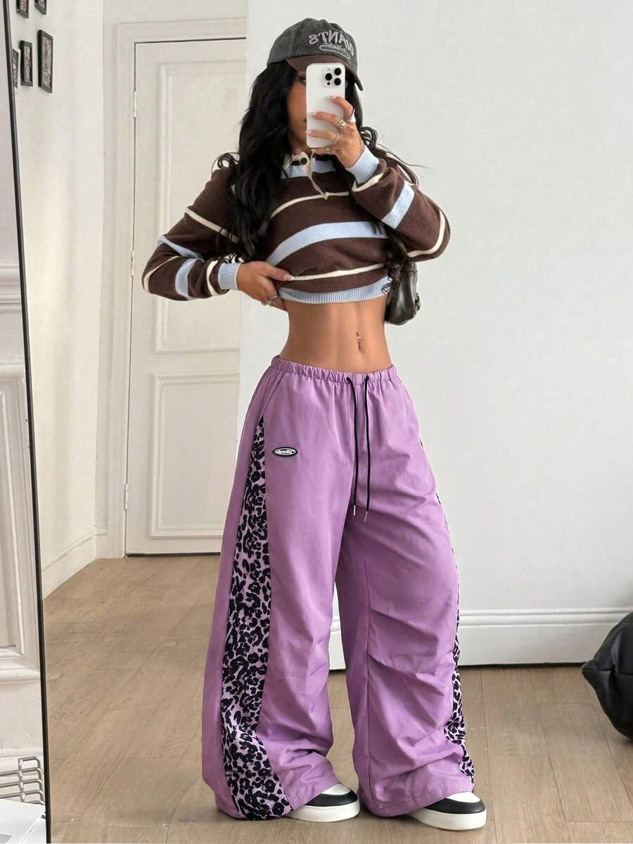 Women's black baggy jogger pants with an adjustable drawstring waist and colorblock polka dot geometric pattern.