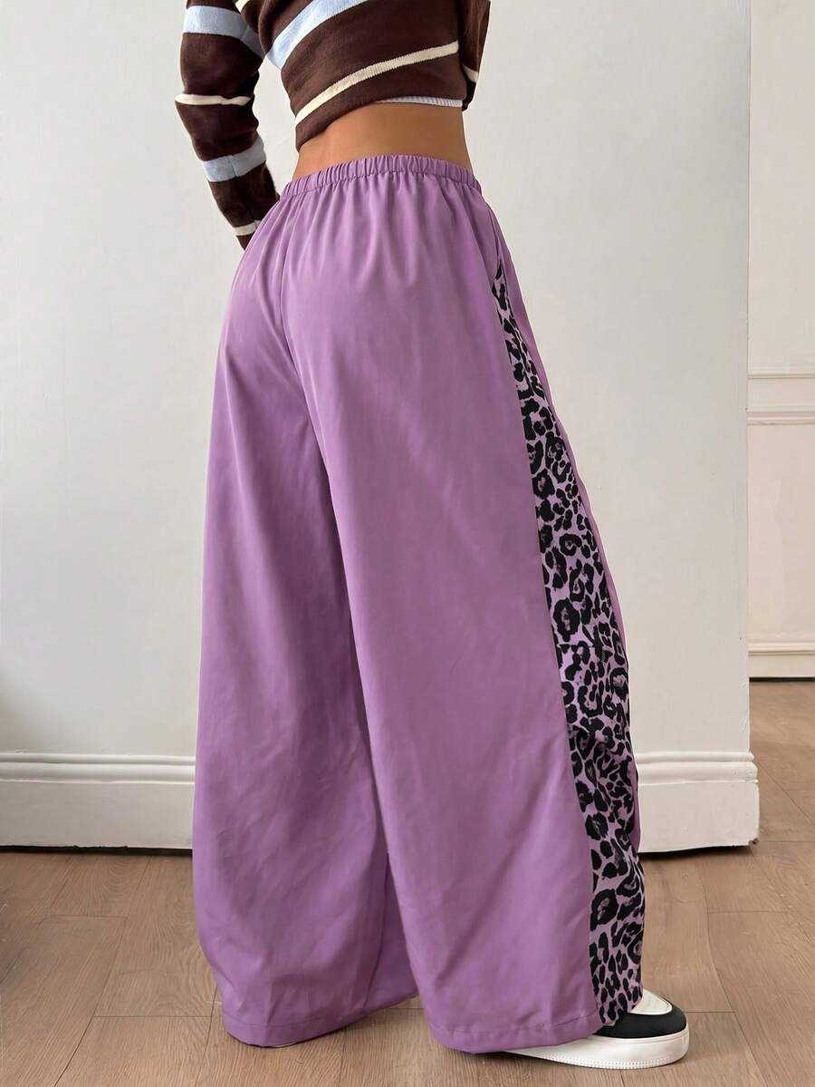 Women's black baggy jogger pants with an adjustable drawstring waist and colorblock polka dot geometric pattern.