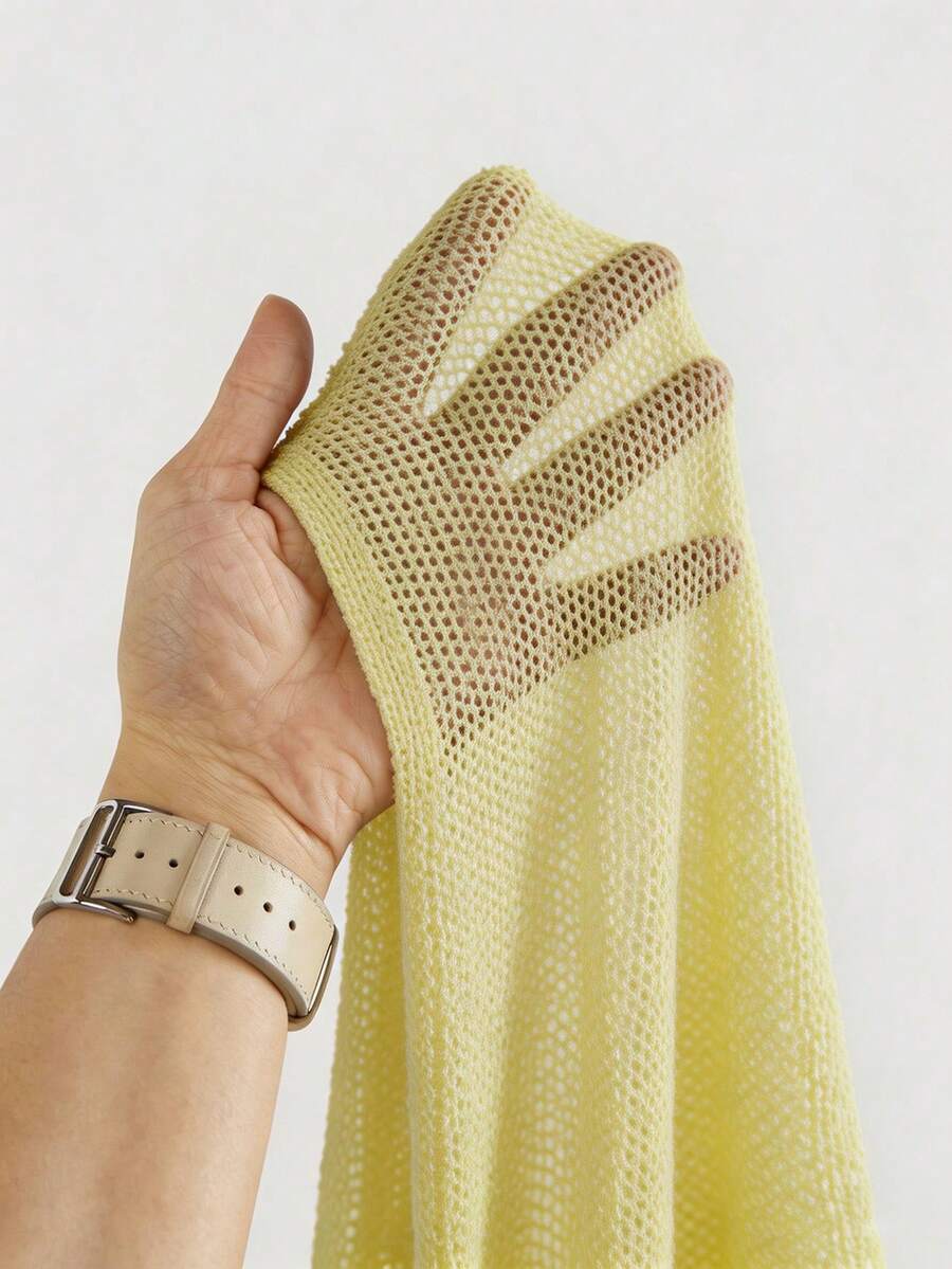 Women's casual hollow knit poncho top with boat neck, cloak sleeves, and asymmetrical hem