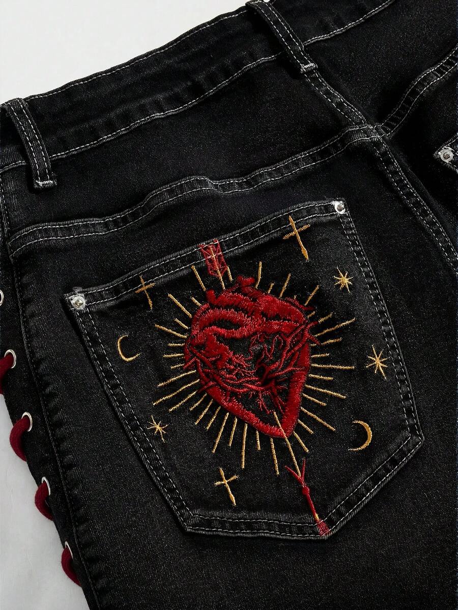 Plus size black gothic mini shorts with heart embroidery, graphic pocket pattern, lace-up detail, raw hem, and zipper fly