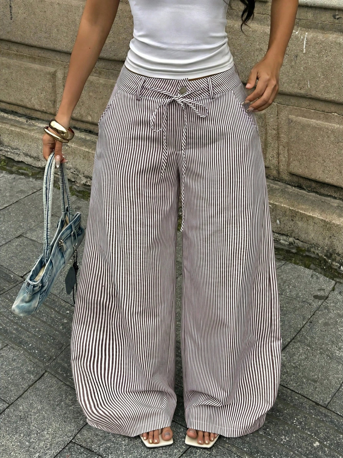 Women's casual straight leg striped woven pants featuring a low waist and zipper fly closure.