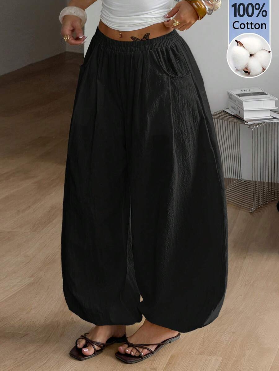 Women's loose-fit black bloomer pants made of 100% cotton featuring an elastic waistband and side pockets.