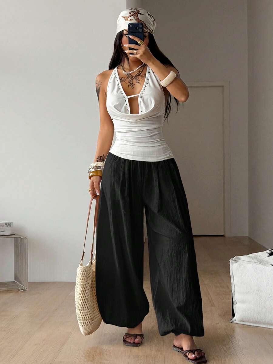 Women's loose-fit black bloomer pants made of 100% cotton featuring an elastic waistband and side pockets.