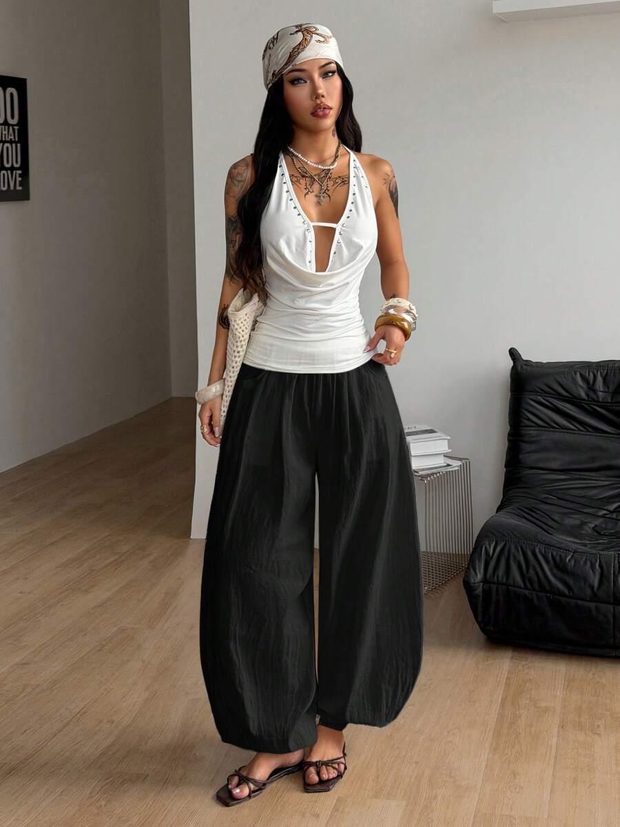 Women's loose-fit black bloomer pants made of 100% cotton featuring an elastic waistband and side pockets.