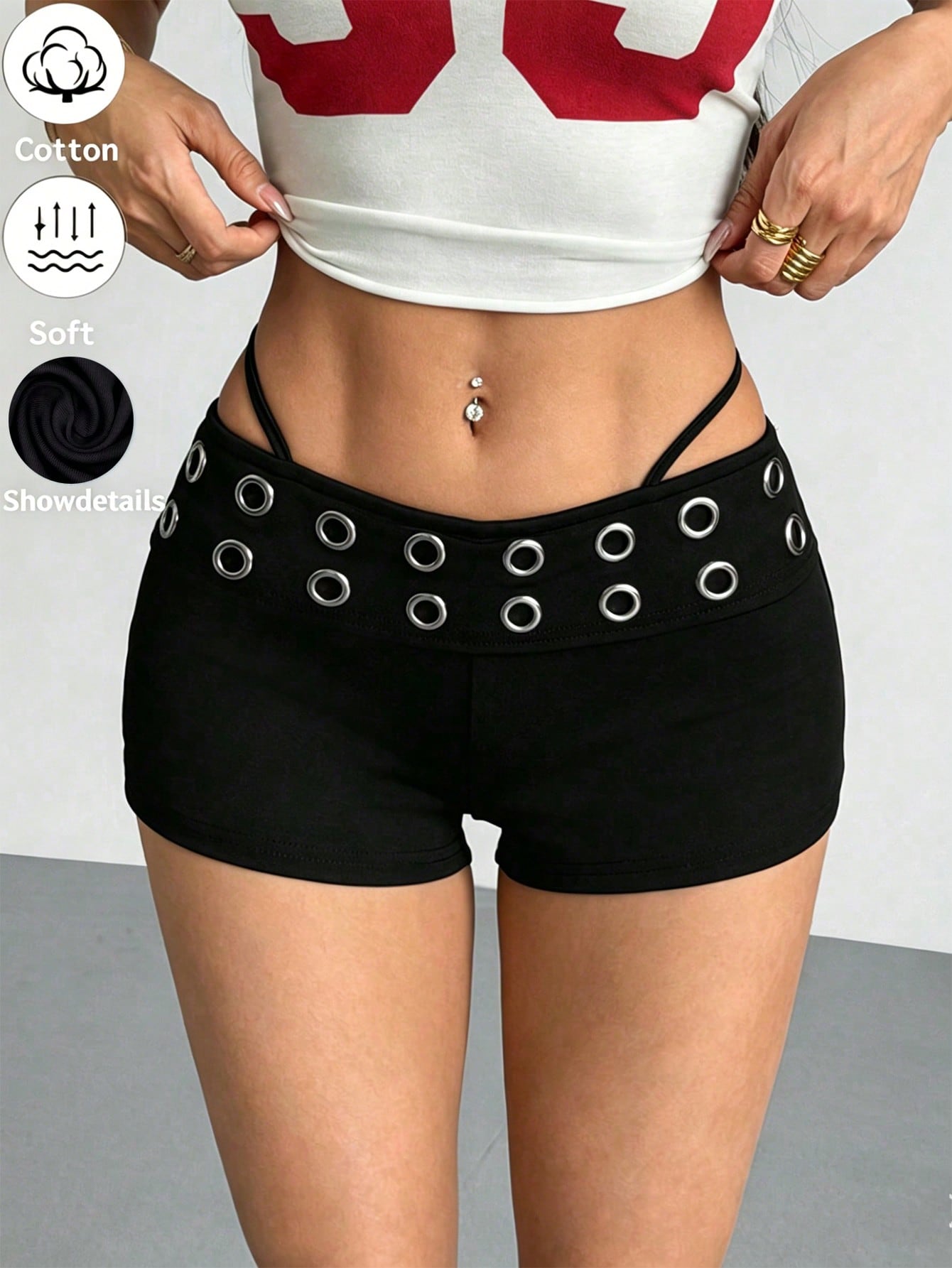 Women's casual track shorts with elastic waist, low-rise mini length, colorblock graphic pattern, and cut-out studded grommet eyelet details.