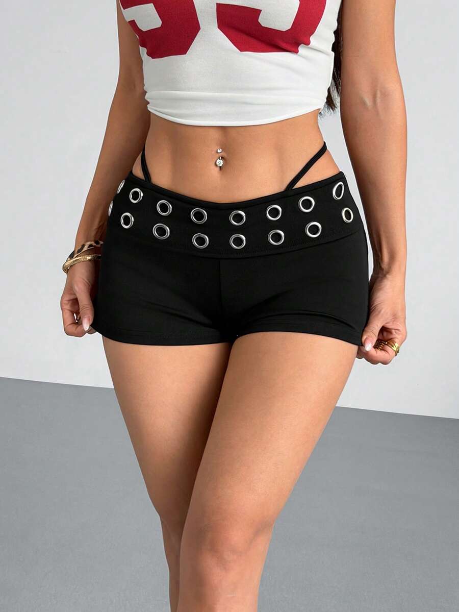 Women's casual track shorts with elastic waist, low-rise mini length, colorblock graphic pattern, and cut-out studded grommet eyelet details.