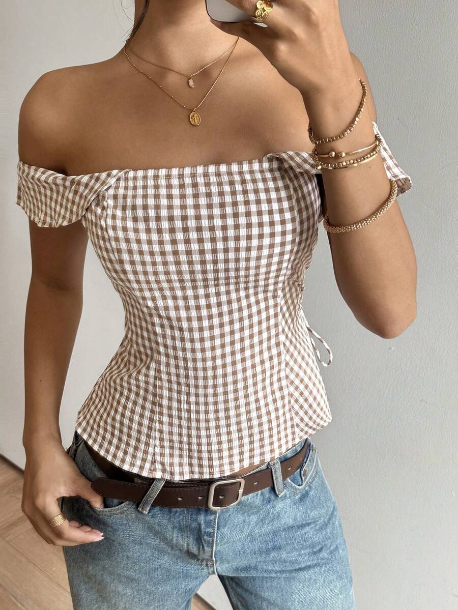 Brown gingham off-the-shoulder crop top for women featuring a slim fit, ruched design, cap sleeves, and knot detail.