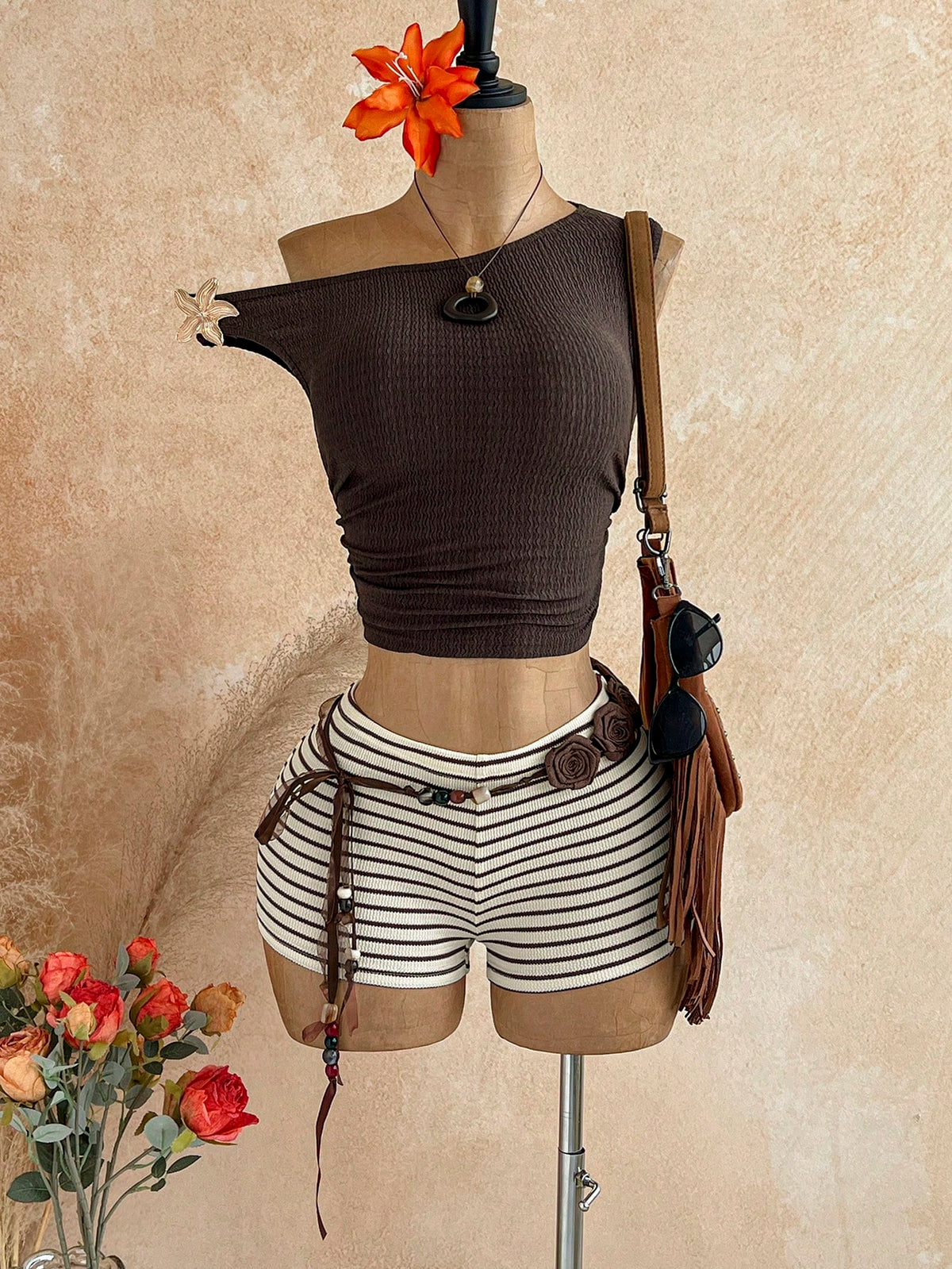 Women's black fuzzy knit two-piece set with an asymmetrical crop camisole top featuring ruched detail and cutout back, paired with matching mini shorts.