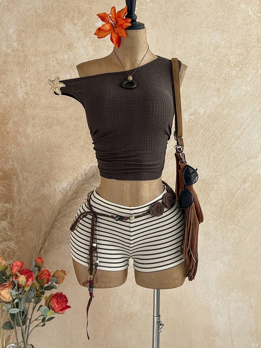 Women's black fuzzy knit two-piece set with an asymmetrical crop camisole top featuring ruched detail and cutout back, paired with matching mini shorts.