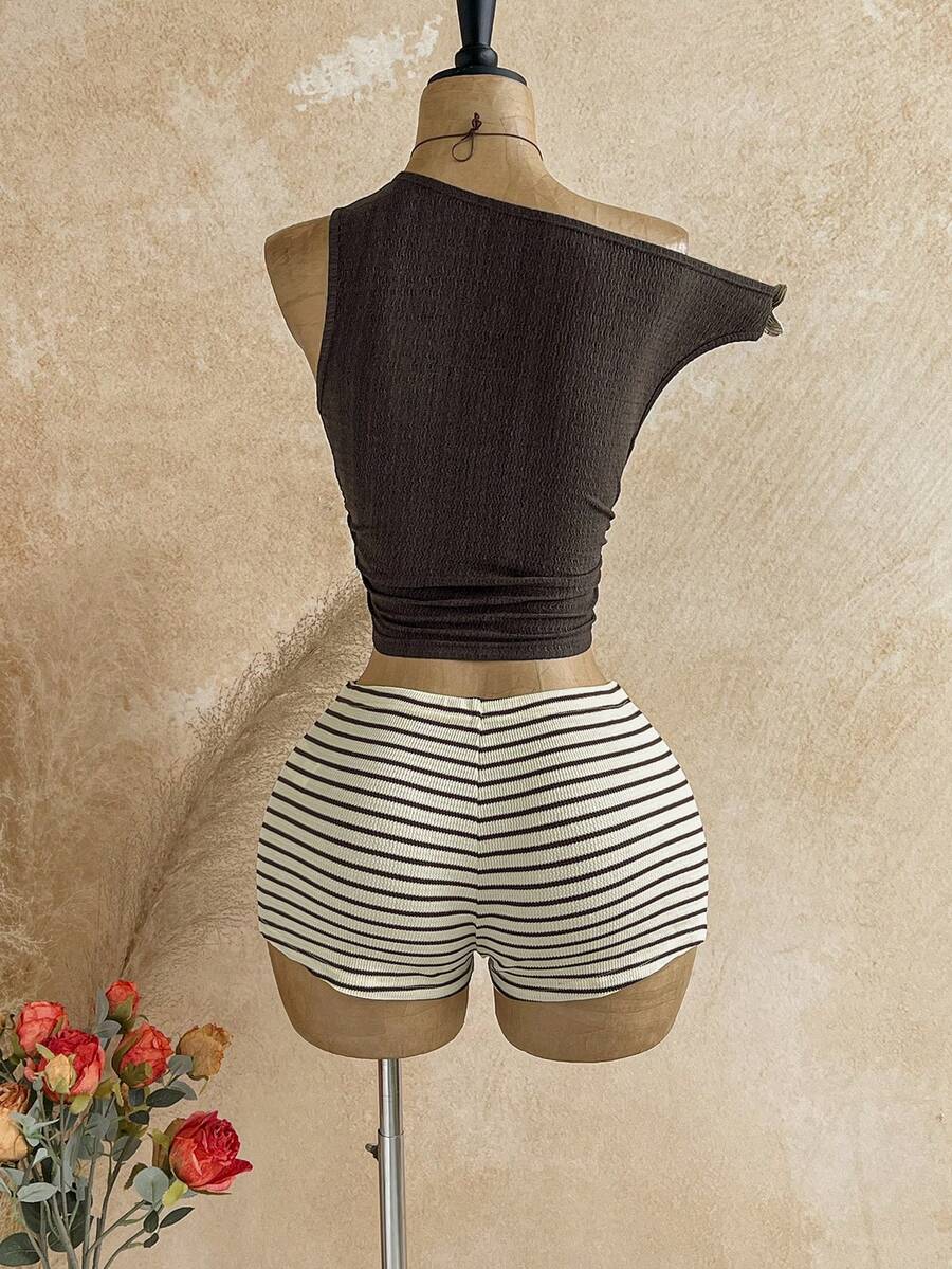 Women's black fuzzy knit two-piece set with an asymmetrical crop camisole top featuring ruched detail and cutout back, paired with matching mini shorts.