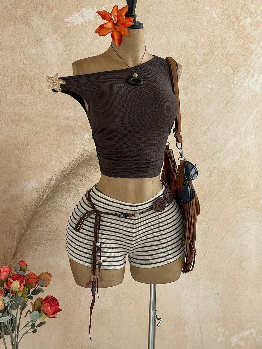 Women's black fuzzy knit two-piece set with an asymmetrical crop camisole top featuring ruched detail and cutout back, paired with matching mini shorts.