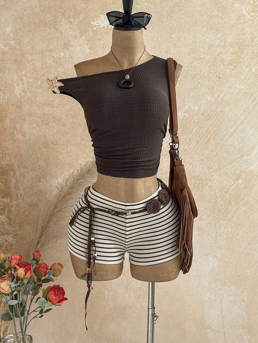 Women's black fuzzy knit two-piece set with an asymmetrical crop camisole top featuring ruched detail and cutout back, paired with matching mini shorts.