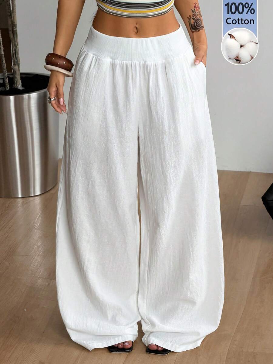 Women's white 100% cotton straight leg pants with an elastic drawstring waist and side pockets, styled in a loose casual fit.