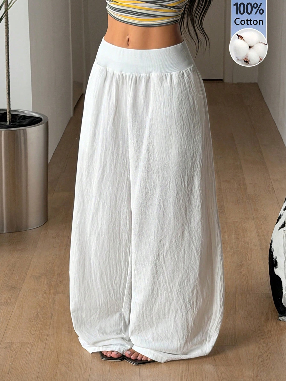 Women's white 100% cotton straight leg pants with an elastic drawstring waist and side pockets, styled in a loose casual fit.