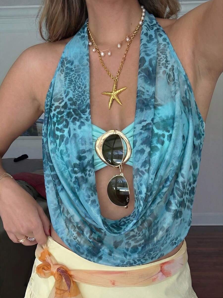 Brown and white polka dot semi-sheer halter camisole top with a plunging neckline, backless design, draped front, and metallic studded embellishments.